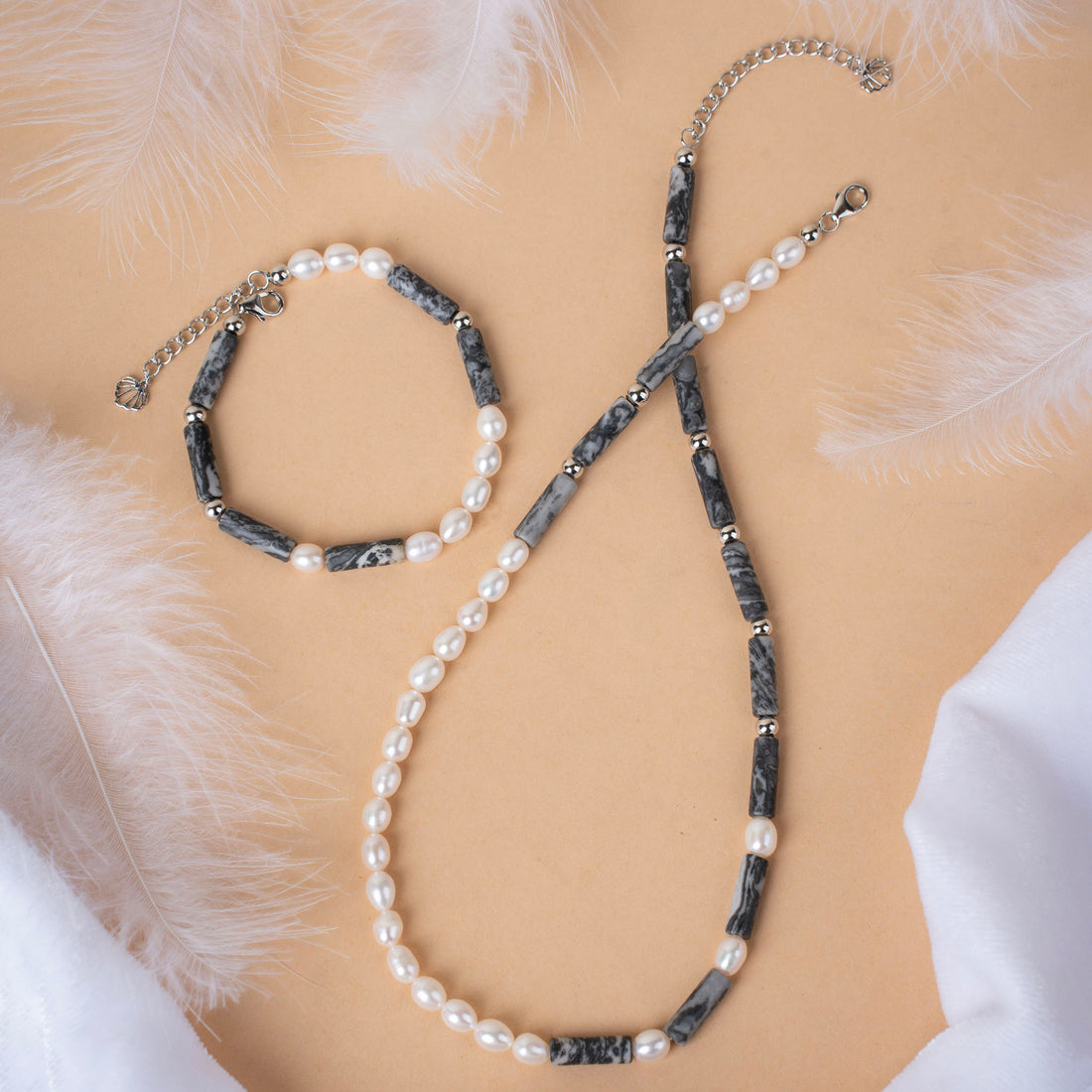 Woman wearing a necklace with visible beads labeled 'Natural Snowflake Obsidian', 'Silver Beads', and 'Silken White'.