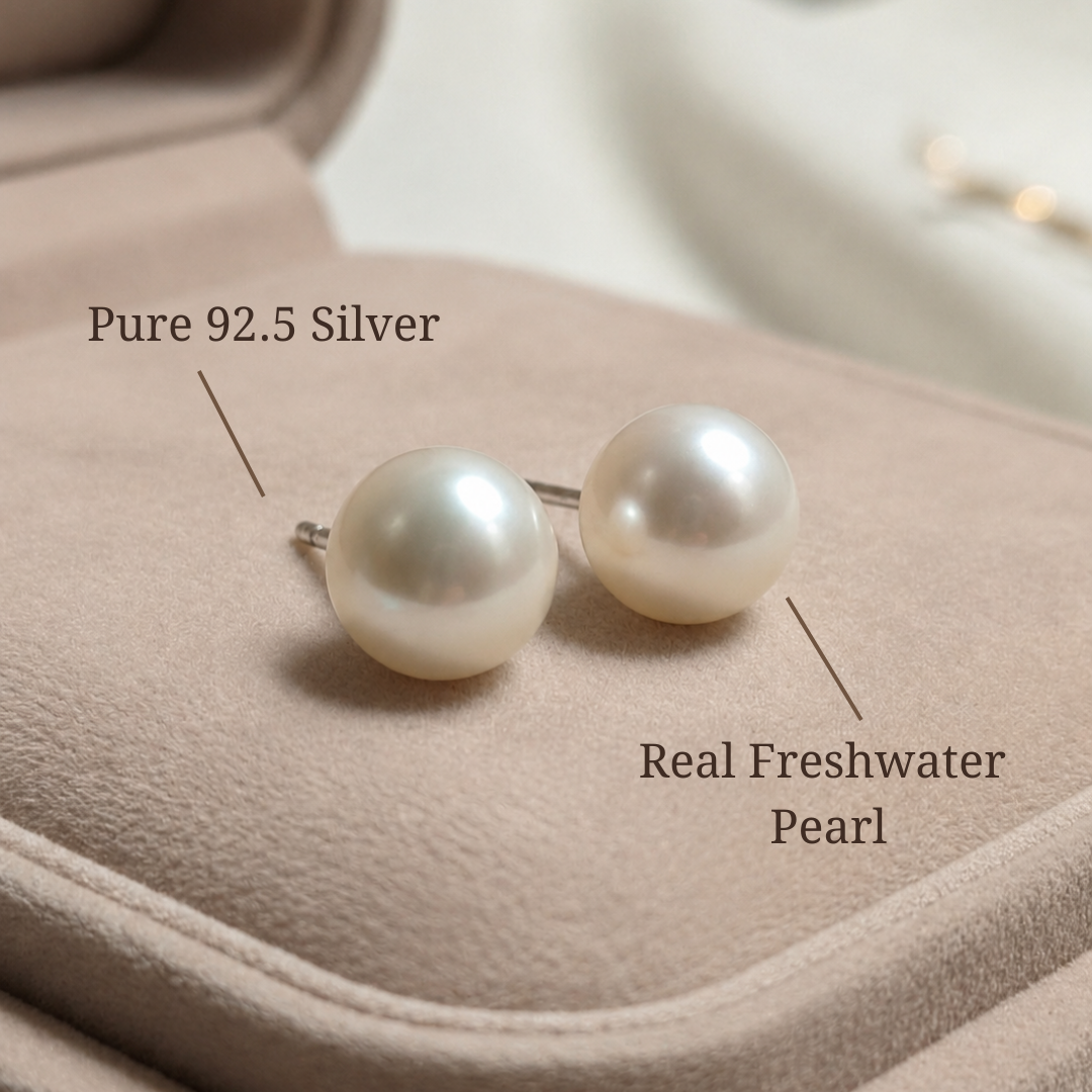 Pearl earrings with silver posts on a soft fabric background, labeled as pure 92.5 silver and real freshwater pearls.