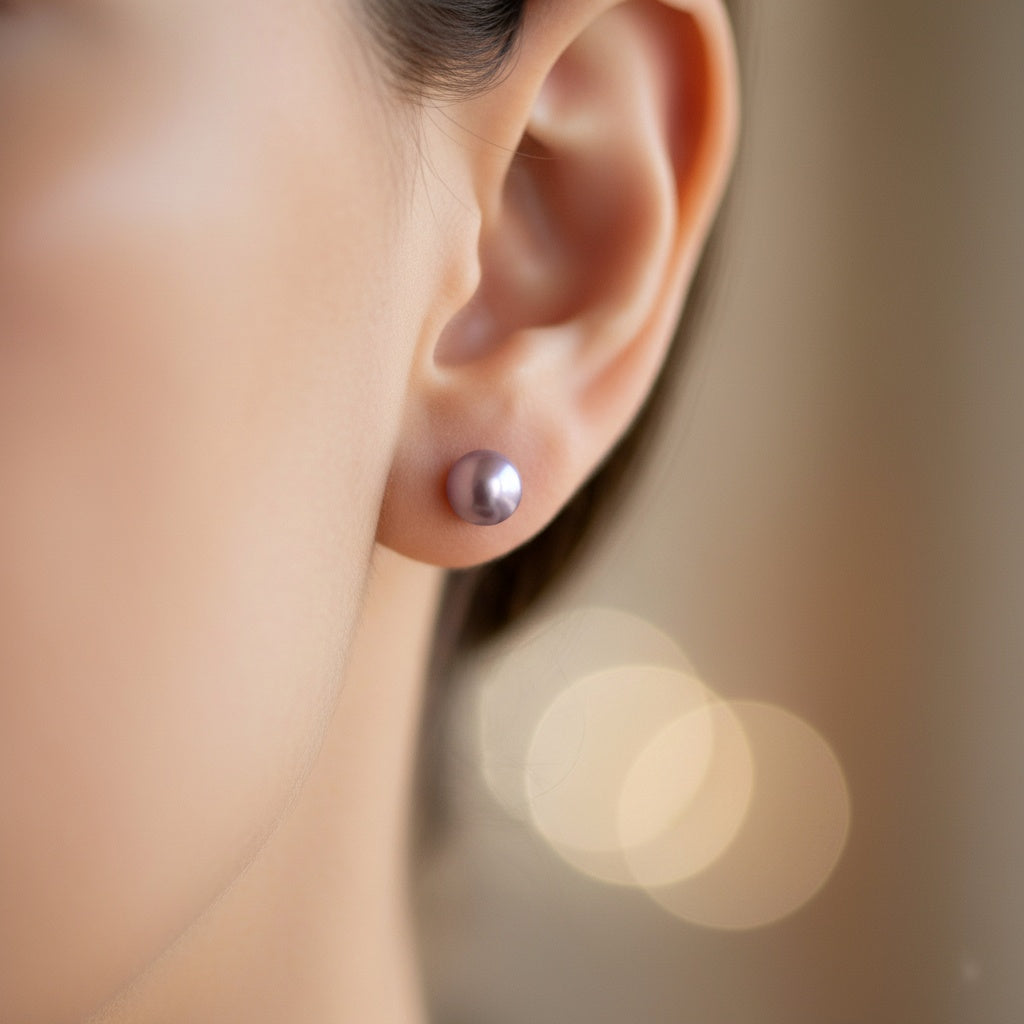 Close-up of an ear wearing a silver earring with a blurred background