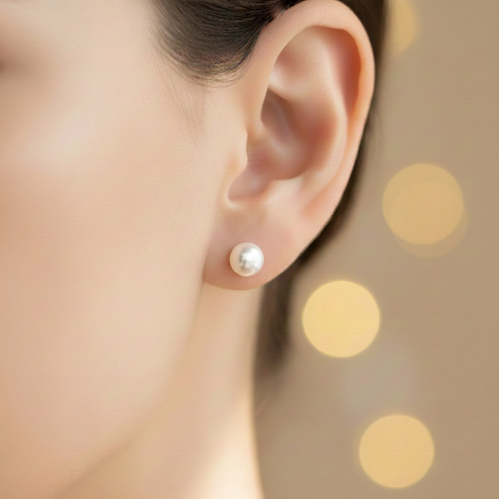 Pearl earring worn by a person with a blurred polka dot background